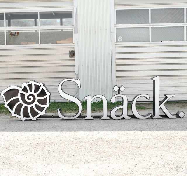 FASADSKYLT. Snäck. Plåt och plexi.